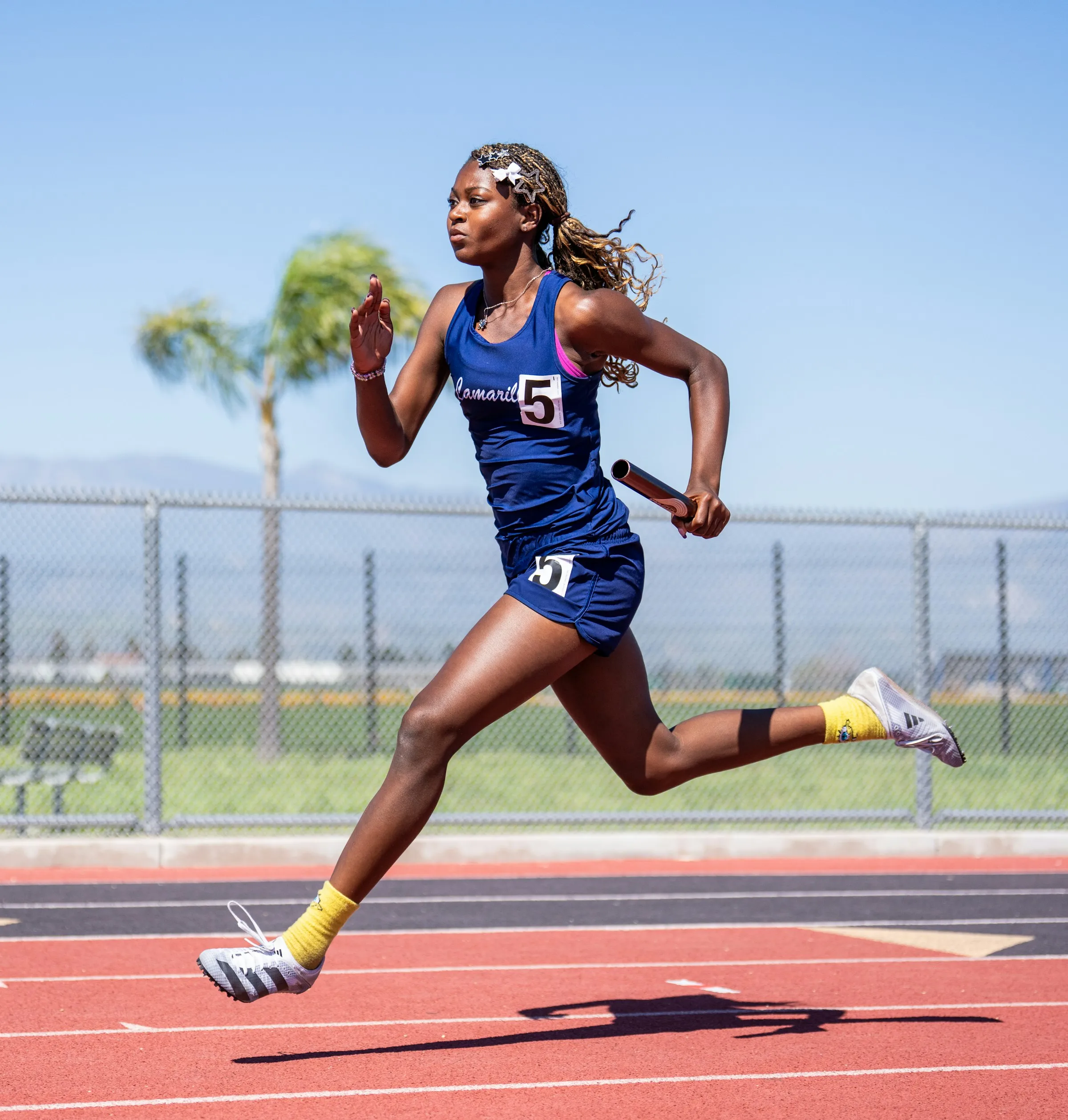 A sprinter at full speed on the track under a blue sky
