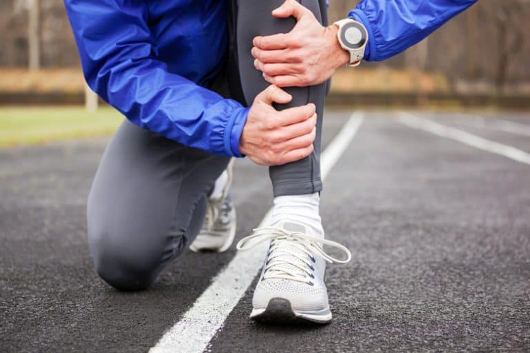 runner holding his leg in pain