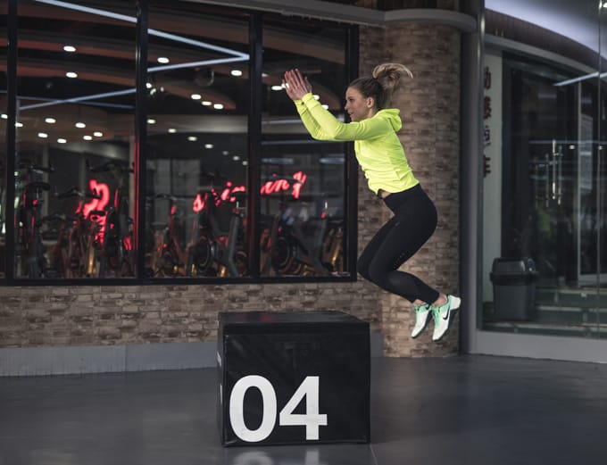 An athlete performing a box jump during training