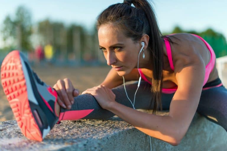 athlete stretching her hamstrings