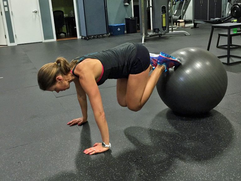 A woman performing ab exercises with a swiss ball